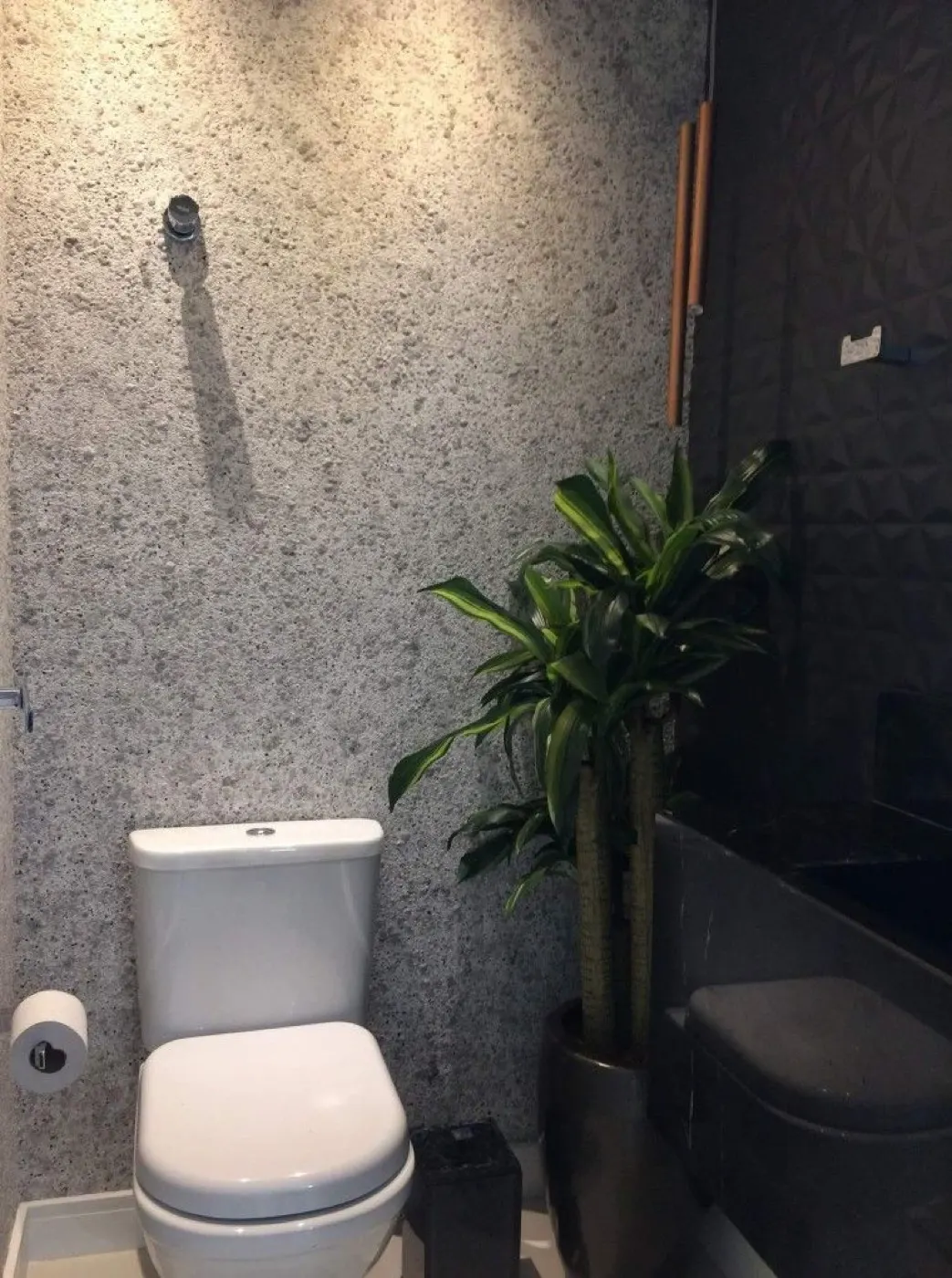Lavabo com parede revestida em pedra natural tom cinza